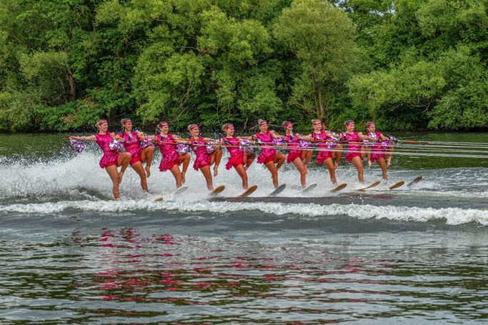 Damenballett auf Wasserski, 10 Frauen im rosa Glitzerkostüm