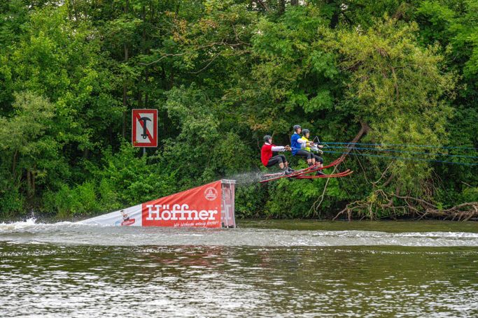 3 Wasserskiläufer springen über eine Schanze